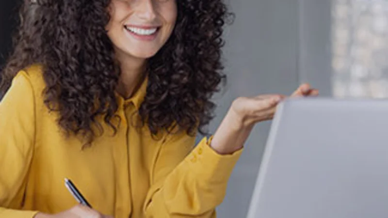 Lächelnde Erzieherin, die an einer Online-Schulung für das KITA-Management teilnimmt.