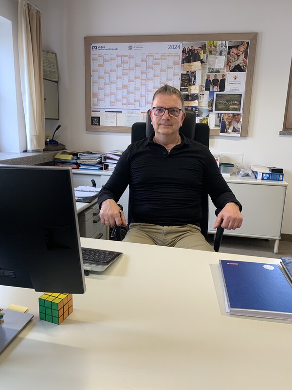 Reinhard Deinböck am Schreibtisch sitzend