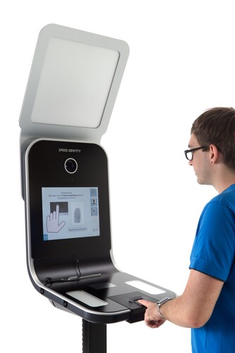 Junger Mann steht vor einem Foto-Terminal.